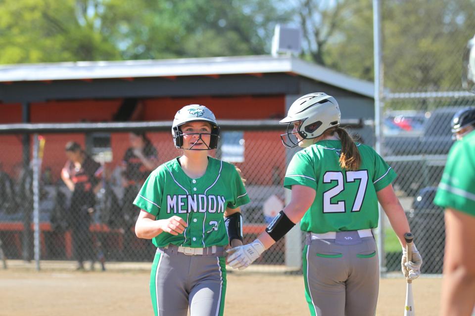 Ally Butler and Rowan Allen share a low-five after Allen scored a run for Mendon on Wednesday.
