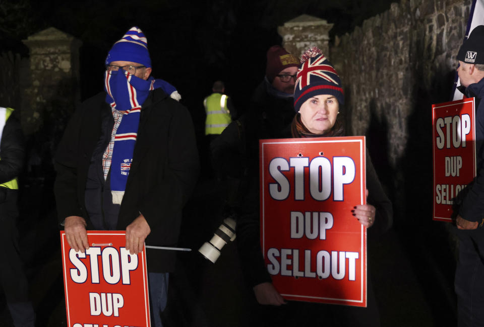 Loyalists protest outside the grounds were the Democratic Unionist Party executive meeting is taking place at Larchfield Estate in Lisburn, Northern Ireland, Monday, Jan. 29, 2024. The Unionist leader is meeting with his executive members to work on a deal to restore power-sharing at Stormont on Monday. The 130 strong-party executive was invited at short notice Monday to a secure venue as it is expected to be picked by Loyalist protesters opposed to returning to power. (AP Photo/Peter Morrison)
