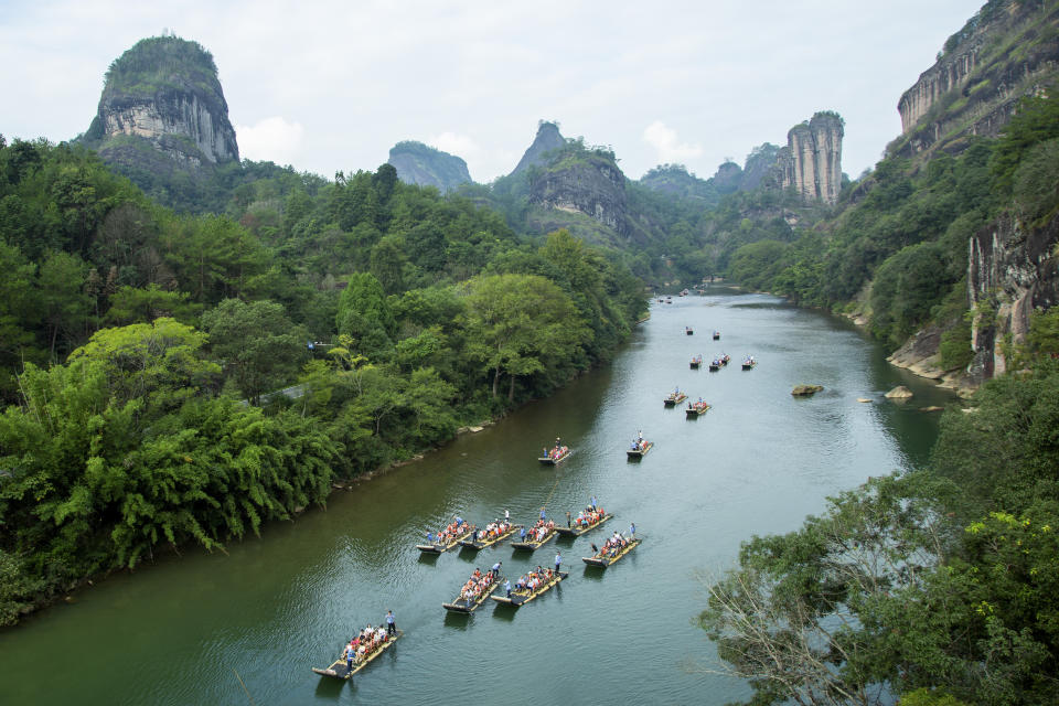 In this photo released by Xinhua News Agency, tourists on bamboo rafts tour the Jiuqu river at a Wuyi mountain scenic area in southeast China's Fujian Province on Oct. 3, 2023. Tourism in China bounced back to pre-pandemic levels during a recent eight-day national holiday, giving a temporary boost to the nation's flagging economy. (Chen Ying/Xinhua via AP)