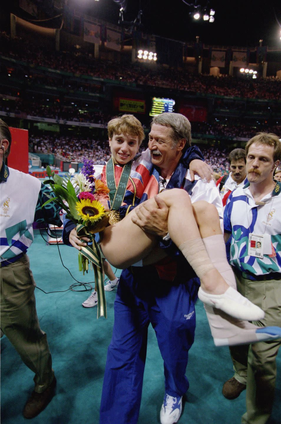 <p>When Kerri Strug first represented the United States at the 1992 Olympics, she was the team's youngest athlete at just 14 years old. Four years later, she competed as one of the Magnificent Seven where she famously <a href="https://www.strug.org/" rel="nofollow noopener" target="_blank" data-ylk="slk:injured her ankle;elm:context_link;itc:0;sec:content-canvas" class="link ">injured her ankle</a> on the vault but carried on with her routine to win the United States the team gold medal. </p>