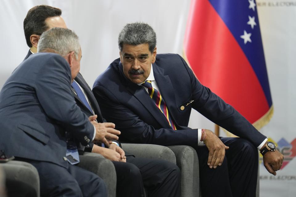 Venezuelan President Nicolas Maduro, right, speaks with presidential candidate Luis Martinez, during a signing agreement ceremony to respect the results of the upcoming presidential elections, at the National Electoral Council headquarters in Caracas, Venezuela, Thursday, June 20, 2024. (AP Photo/Ariana Cubillos)