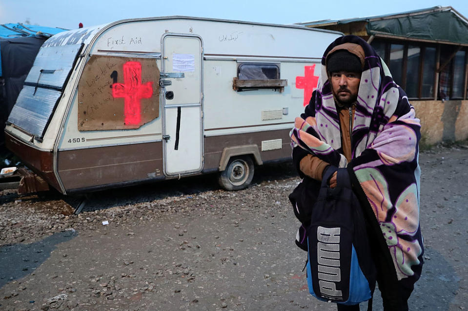 A resident tries to keep warm on his way out of the camp. 