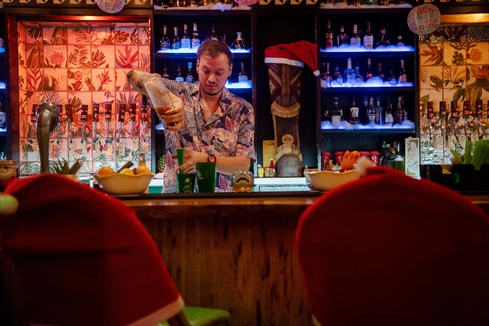 John Gibson makes a Sharkey’s First Christmas cocktail from the Sippin’ Santa menu at The Tiki Easy Bar in Asheville, November 20, 2023.