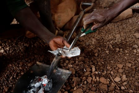 Informal gold miners burn off mercury from a gold nugget at the site of Nsuaem-Top