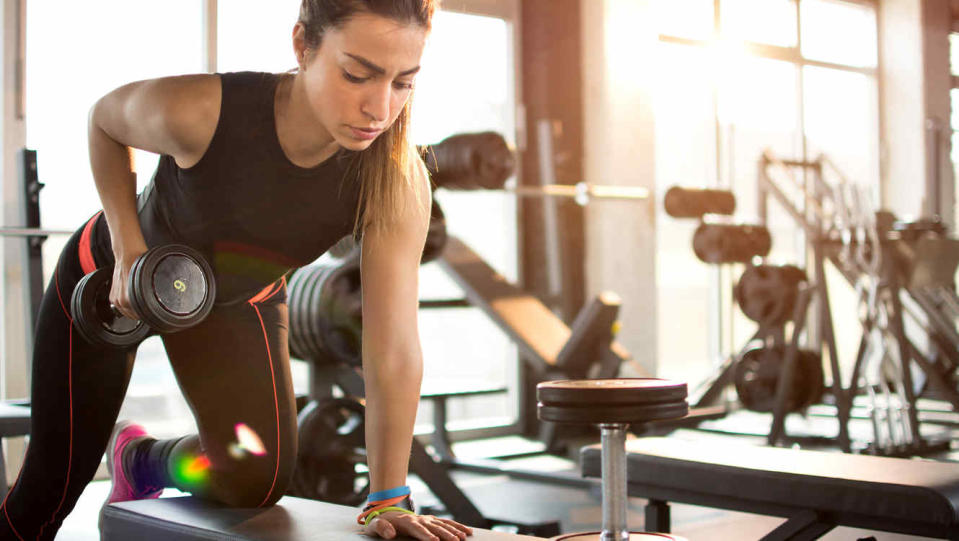 Mujer joven haciendo ejercicio con mancuernas