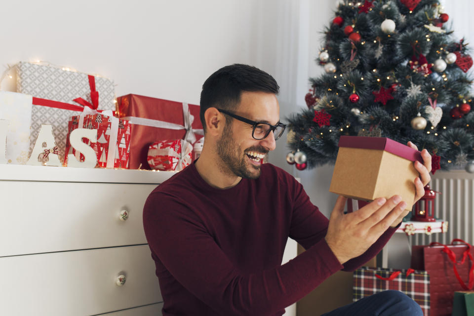 Smiling young man looking at his Christmas present.