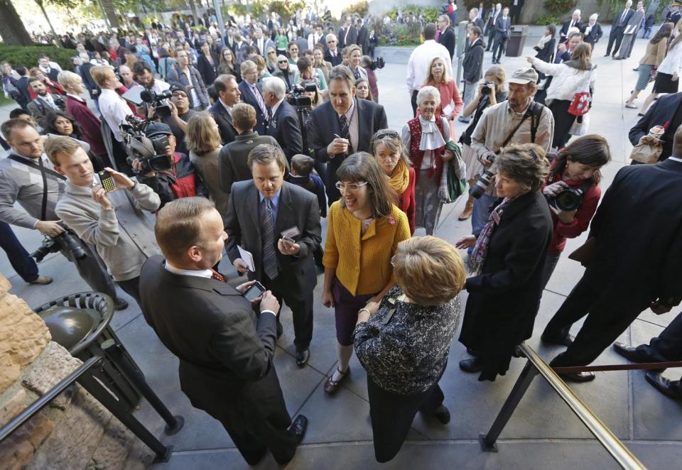 FILE - In this Oct. 5, 2013,file photo, Kate Kelly, center, with a group of about 200 feminist women are denied entrance to an all-male meeting of Mormon priesthood during the Mormon church conference, in Salt Lake City. More than 100,000 Latter-day Saints are expected in Salt Lake City this weekend for the church's biannual general conference. A Mormon's women group pushing the church to allow women in the priesthood plans to demonstrate outside an all-male meeting Saturday. The church has asked them to reconsider, and barred media from going on church property during the demonstration. (AP Photo/Rick Bowmer, File)