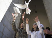 Newlyweds, soldier Hovhannes Hovsepyan, left, and Mariam Sargsyan release pigeons after their wedding ceremony in the Holy Savior Cathedral, damaged by shelling by Azerbaijan's artillery during a military conflict in Shushi, the separatist region of Nagorno-Karabakh, Saturday, Oct. 24, 2020. The wedding was celebrated even as intense fighting in the region has continued. (AP Photo)