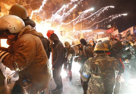 Fireworks explode near anti-government protester during clashes with riot police at the Independence Square in Kiev February 18, 2014. REUTERS/Vasily Fedosenko