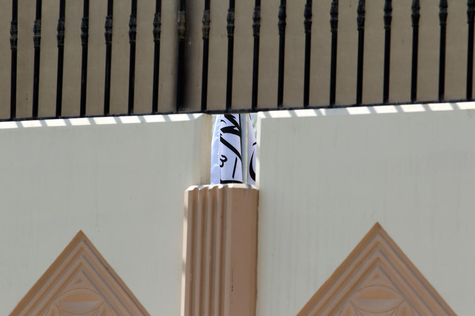 FILE - This Thursday, June 20, 2013 file photo shows the Taliban flag visible through a gap in a wall of the new office of the Afghan Taliban in Doha, Qatar after the opening of the office several days ago. Secret contacts are again reported to be underway for an Afghanistan peace deal, but neither analysts nor the belligerents see hope they will succeed. (AP Photo/Osama Faisal, File)