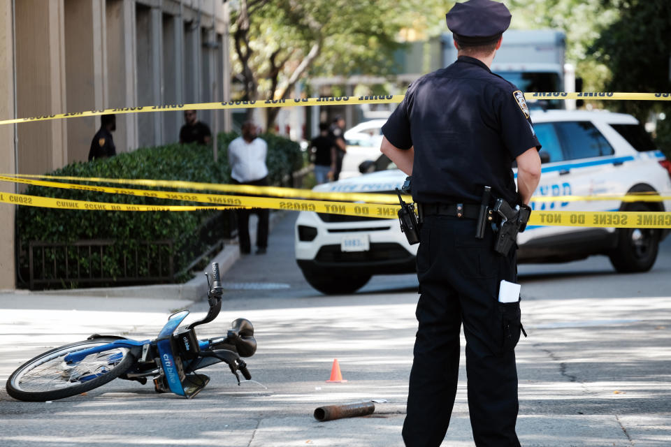 An officer stands near a Citi Bike at the scene of a shooting in Alphabet City in lower Manhattan.