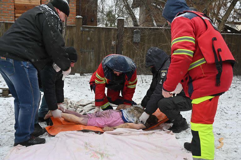 Rescatistas llevan el cuerpo de una víctima después de los ataques rusos en Zmiiv, región de Kharkiv, el 8 de enero de 2024, en medio de la invasión rusa de Ucrania. 