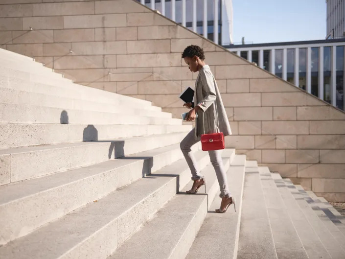 a busy business woman walking up stairs