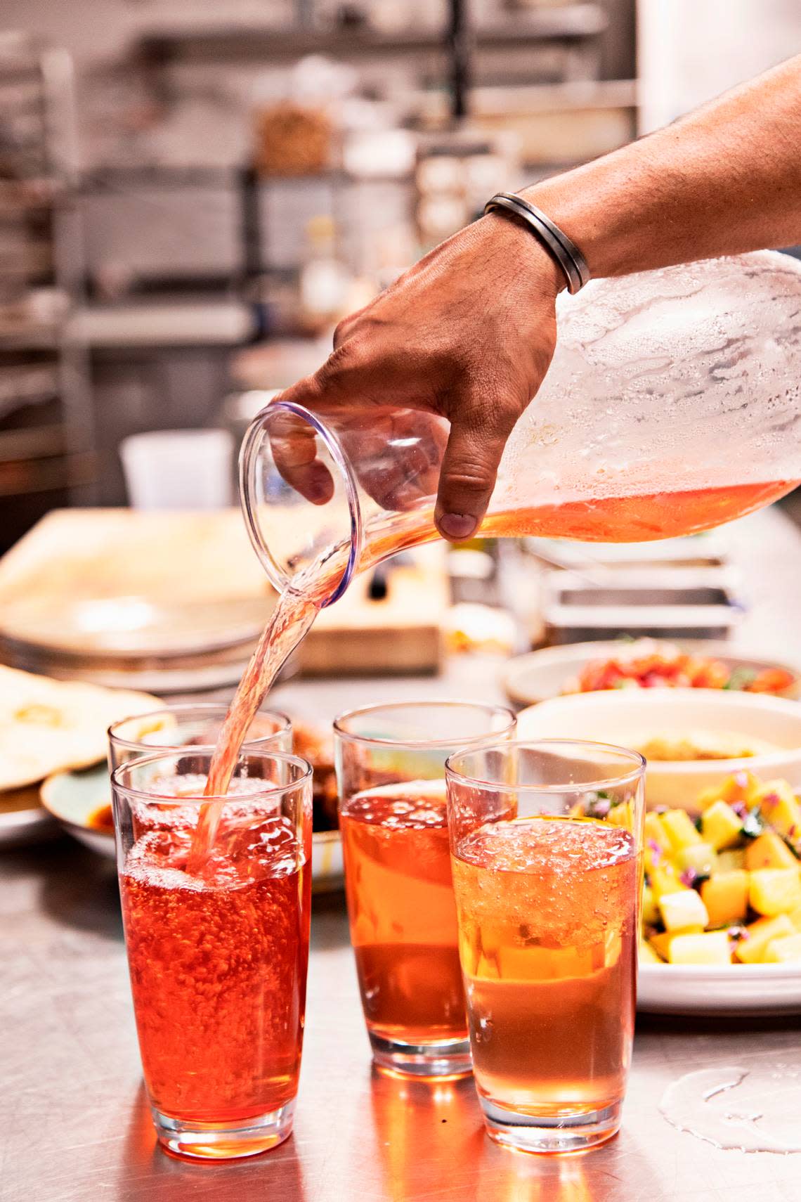 Vidrio chef Saif Rahman pours drinks for kitchen staff during a short break during dinner service on Tuesday, April 26, 2022, to break fast.