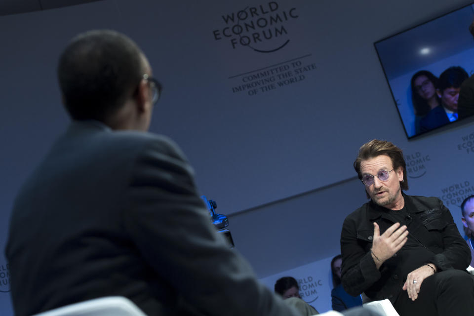 Irish singer Bono, right, speaks in front of Rwanda President Paul Kagame, left, during a panel session during the the 49th Annual Meeting of the World Economic Forum, WEF, in Davos, Switzerland, Wednesday, Jan. 23, 2019. (Laurent Gillieron/Keystone via AP)