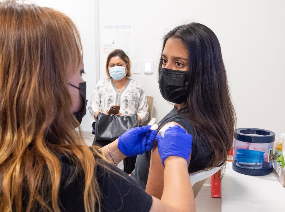 A 16-year-old getting her Pfizer-BioNTech COVID-19 vaccine