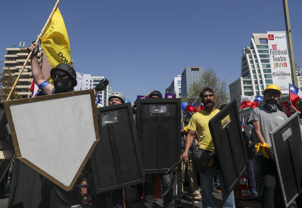 Un grupo de manifestantes portan escudos al lanzar consignas contra la creación de una nueva Constitución que reemplazaría la Carta Magna heredada de la dictadura de Augusto Pinochet, en Santiago de Chile, el sábado 22 de febrero de 2020. El documento será sometido a un referendo en abril, (AP Foto/Esteban Felix)