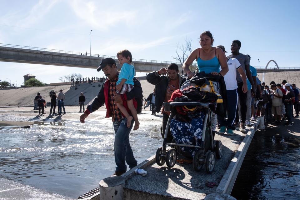 <p>A group of Central American migrants -mostly from Honduras- cross the almost dry riverbed of the Tijuana River in an attempt to get to El Chaparral port of entry, in Tijuana, Baja California State, Mexico, near US-Mexico border on November 25, 2018.</p>