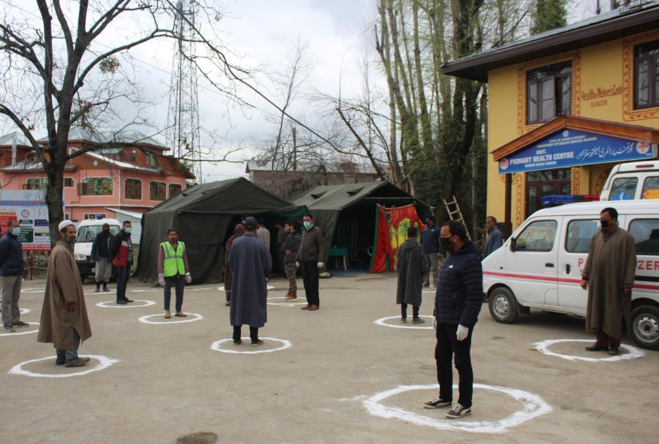 People stand in designated area to maintain social distance as they queue up outside a Government Hospital at Baramulla in North of Srinagar, Indian administered Kashmir in India. Source: Sipa USA