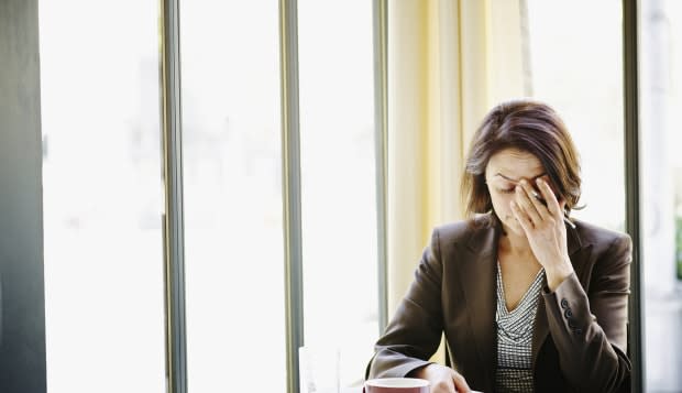 Businesswoman at table with head resting on hand