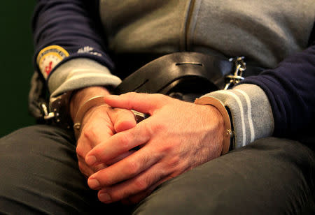 The hands of Syrian-Cypriot Ahmed Hamed are cuffed as a Hungarian court hands down a seven-year prison sentence for illegally crossing the border and playing a part in a riot at Hungary's border with Serbia in September 2015, in Szeged, Hungary March 14, 2018. REUTERS/Bernadett Szabo