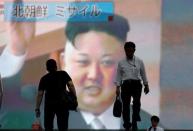 Men walk past a street monitor showing news of North Korea firing a ballistic missile, in Tokyo, Japan, July 4, 2017. REUTERS/Toru Hanai/Files