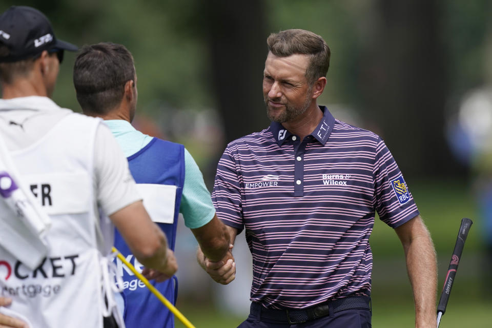 Webb Simpson shakes hands with his playing partners and caddies after the first round of the Rocket Mortgage Classic golf tournament, Thursday, July 28, 2022, in Detroit. (AP Photo/Carlos Osorio)