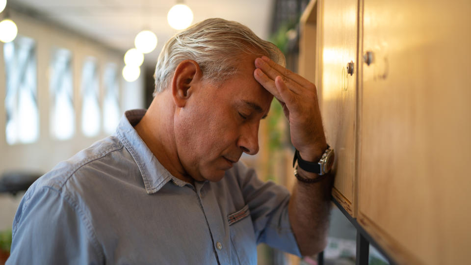 middle age man feeling stressed in office.