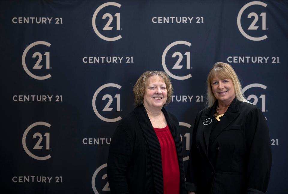 Mary Pierce (left), Melissa Frank both of Darfus Realty, stand in front of a Century 21 backdrop inside of the Century 21 Darfus Realty office on Mar. 18, 2024, in Lancaster, Ohio. Darfus Realty is celebrating their 40th year anniversary with Century 21 this year.