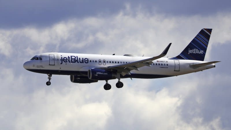 In this Oct. 18, 2019, file photo a JetBlue Airways flight flies in to Salt Lake City International Airport in Salt Lake City. JetBlue says it plans to increase the number of seats it will fill on planes starting in December. (AP Photo/Rick Bowmer, File)