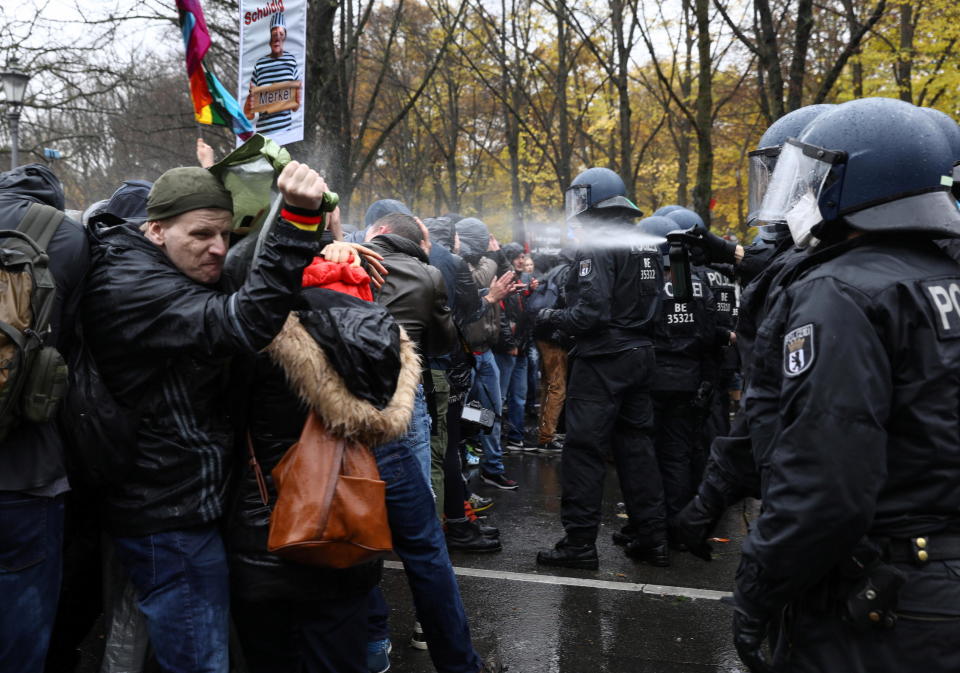 A police officer uses a pepper spray on demonstrators during a protest against the government's coronavirus disease (COVID-19) restrictions, near the Brandenburg Gate in Berlin, November, 18, 2020. / Credit: CHRISTIAN MANG / REUTERS