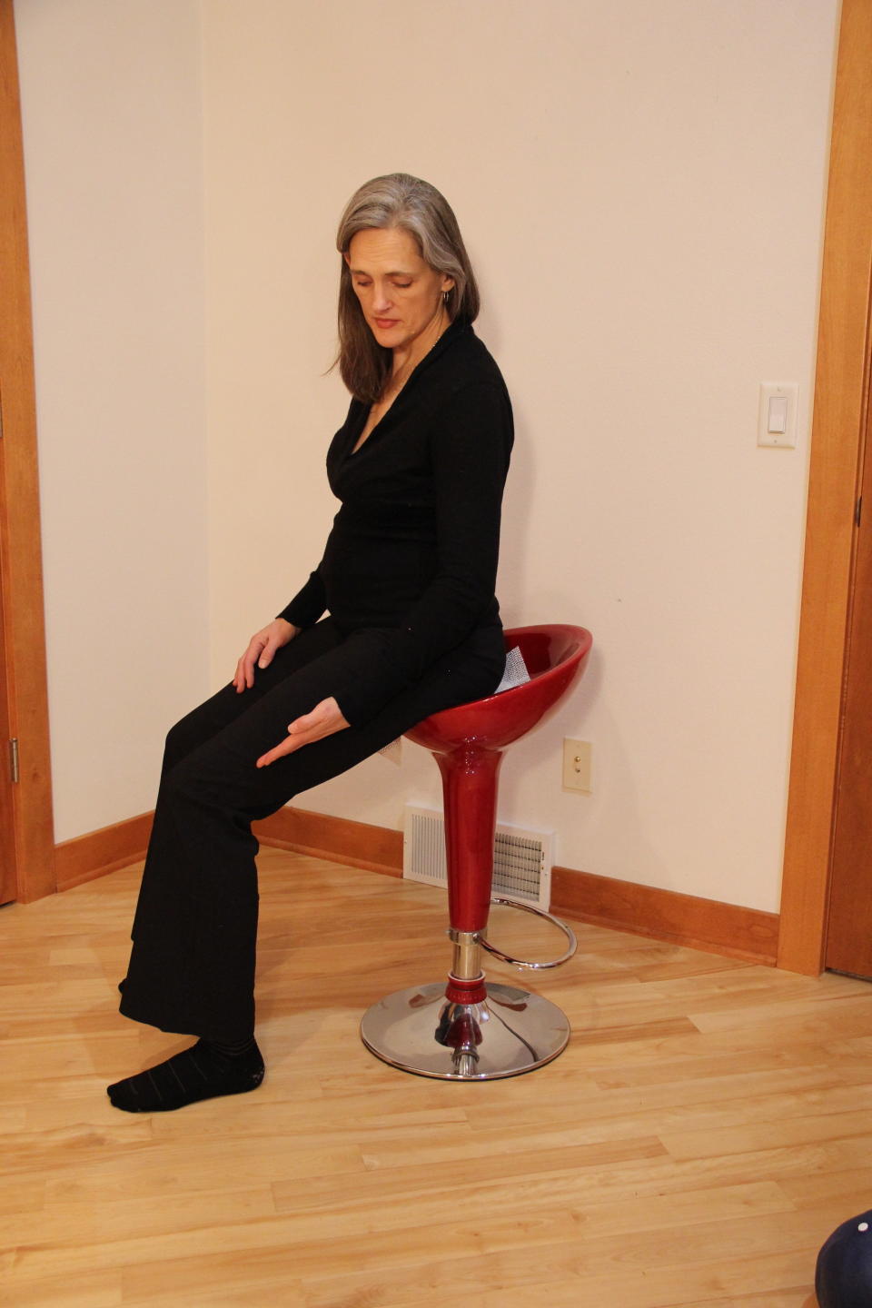 Hilary Bryan demonstrates saddle height on a stool. (Photo: The Body at Work Ergonomics/Sara Kraft)