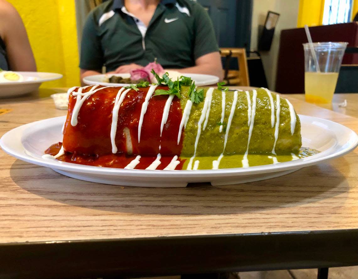 Half of Jimmy’s burrito at Jimmy Peruvian & Mexican Restaurant is slathered in red enchilada sauce; the other half, in green.