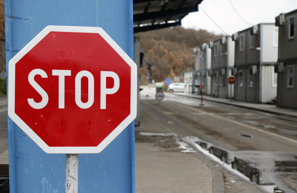 A traffic sign is seen at the closed border crossing of Jarinje, along the Kosovo-Serbia border, Kosovo, Sunday, Dec. 11, 2022. Kosovo police and the local media on Sunday reported explosions, shooting and road blocks overnight in the north of the country, where the population is mostly ethnic Serb, despite the postponement of the Dec. 18 municipal election the Serbs were opposed to. No injuries have been reported. (AP Photo/Marjan Vucetic)