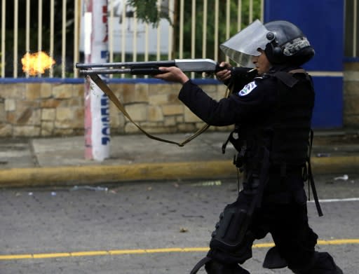 A riot police officer fires a weapon during clashes with students taking part in a protest in Managua on May 28, 2018