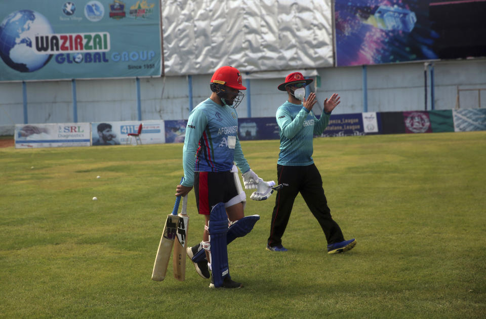 FILE - In this June 10, 2020, file photo, Gulbadin Naib, left, member of the Afghan national cricket team walks after practice during his team's first training camp after the COVID-19 pandemic hit the country at the Kabul national cricket stadium in Kabul, Afghanistan. The pandemic-affected T20 World Cup will finally kick off in Oman and the United Arab Emirates on Sunday, Oct. 17, 2021, with no clear cut favorites this time around. (AP Photo/Rahmat Gul, File)