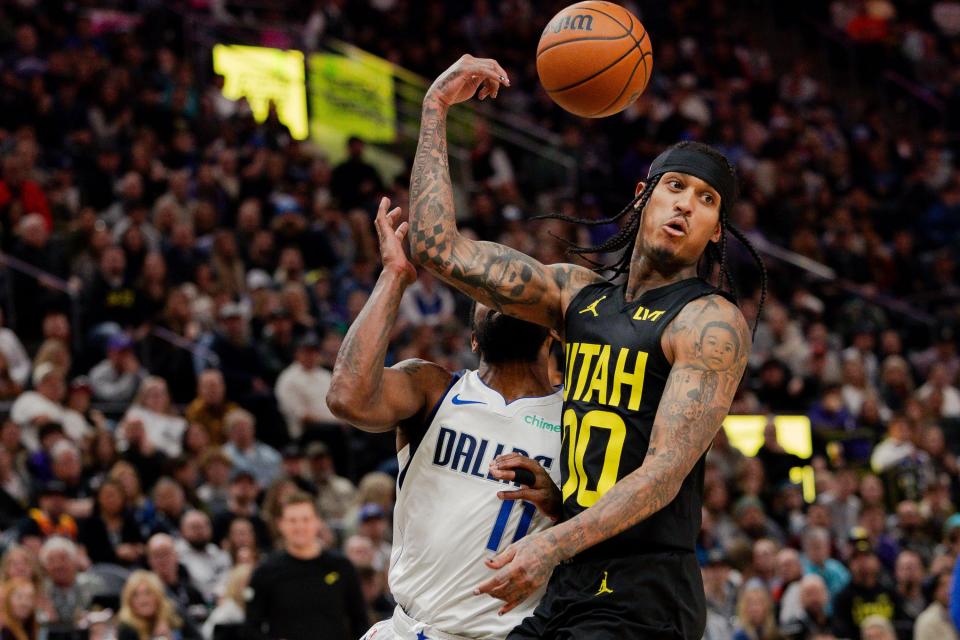 Utah Jazz guard Jordan Clarkson (00) passes the ball over his shoulder in an assist to Utah Jazz guard Kris Dunn (11) on a dunk during the NBA basketball game between the Utah Jazz and the Dallas Mavericks at the Delta Center in Salt Lake City on Monday, Jan. 1, 2024.