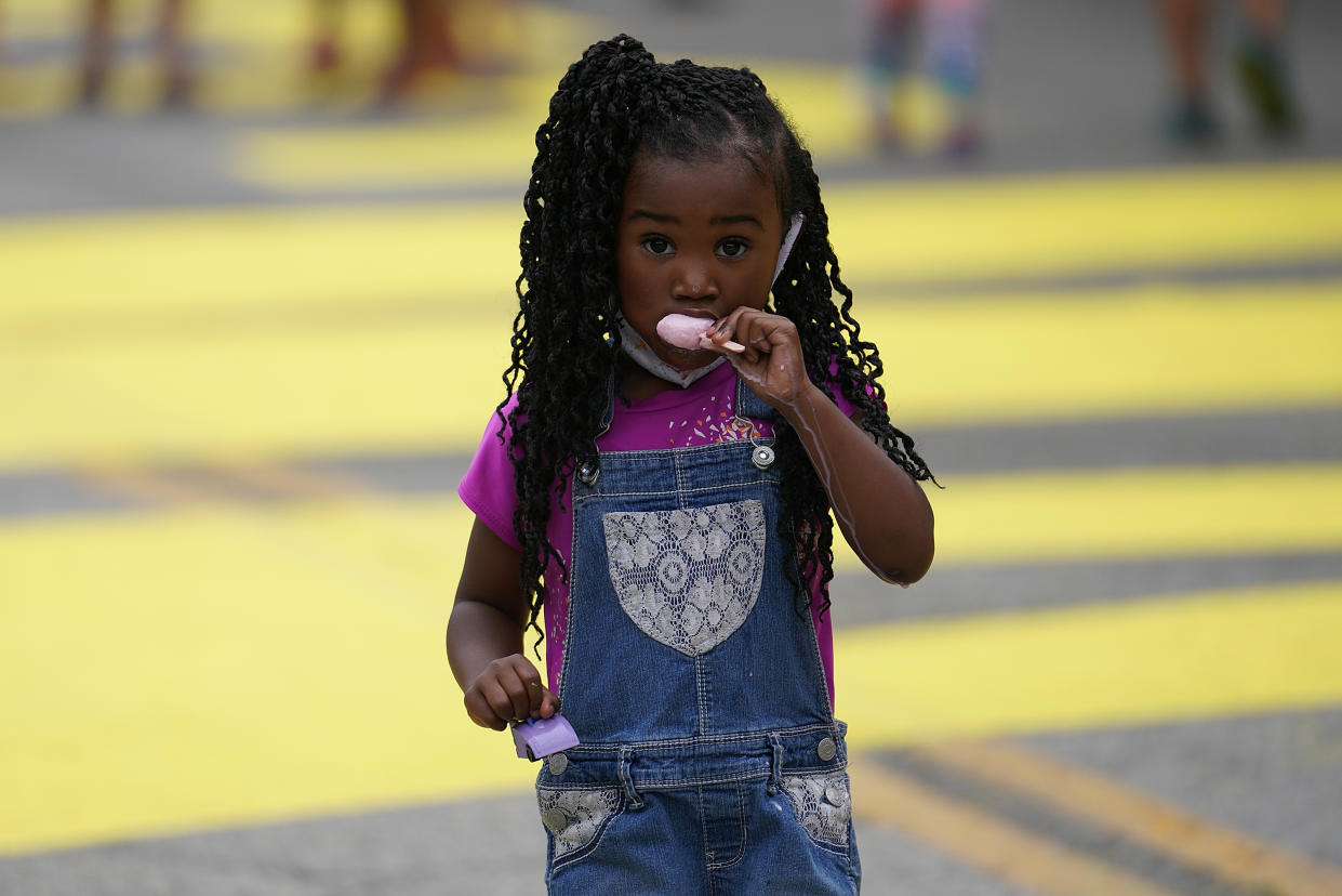 TULSA, OK - JUNE 19: A young girl eats ice cream as she walks along during the Juneteenth celebration in the Greenwood District on June 19, 2020 in Tulsa, Oklahoma. Juneteenth commemorates June 19, 1865, when a Union general read orders in Galveston, Texas stating all enslaved people in Texas were free according to federal law. (Photo by Michael B. Thomas/Getty Images)