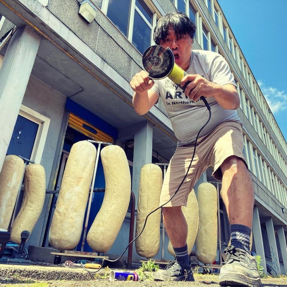 Shiro Masuyama working on the sausage sculptures prior to their completion - News Scan 