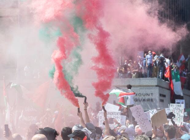 Smoke bombs were set off, and people climbed up on structures like walls and scaffolding during the protest.