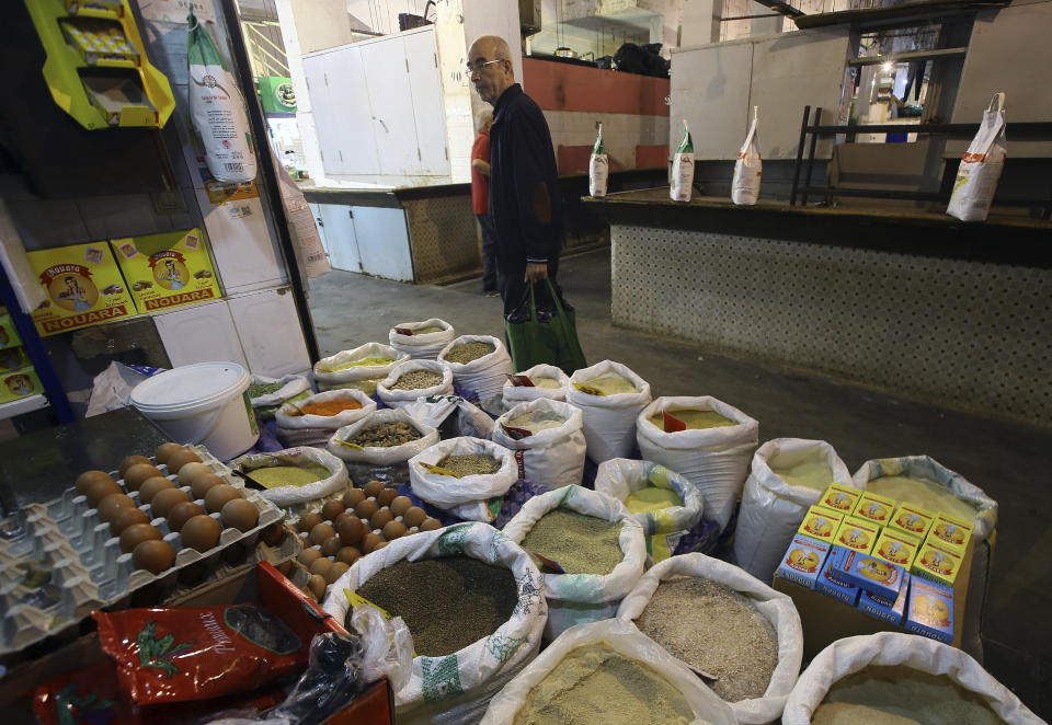 A man stands by food bags in a market near Algiers, Tuesday, March 26, 2024. As Muslim-majority countries reckon with increased demand throughout Islam's holy month of Ramadan, is trying to flood new markets with pantry staples to stave off shortages that can cause prices to rise. (AP Photo/Anis Belghoul)