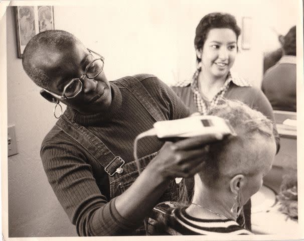 <p>Bruce Levine/Courtesy of Paramount+</p> Betty Dederich, wife of Synanon's founder Chuck, shaving Kathy Sheehan Lewbell's head in Born in Synanon