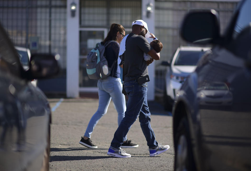 A family arrives at the Department of Family Affairs where many come to apply for the nutritional assistance program, in Bayamon, Puerto Rico, Friday, March 29, 2019. Hundreds of thousands of Puerto Ricans are feeling the sting of what the territorial government says are insufficient federal funds to help the island recover from the Category 4 storm amid a 12-year recession. (AP Photo/Carlos Giusti)