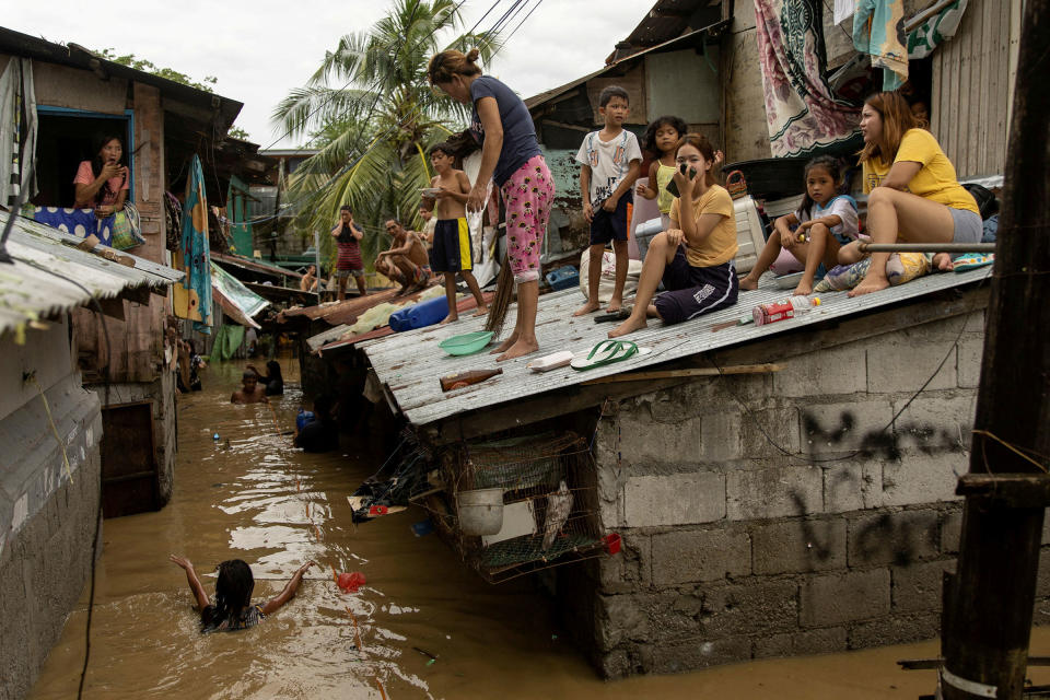 Residents wait on the roof of their homes for the flooding to subside after Super Typhoon Noru, in San Miguel, Bulacan province, Philippines, on Sept. 26.<span class="copyright">Eloisa Lopez—Reuters</span>