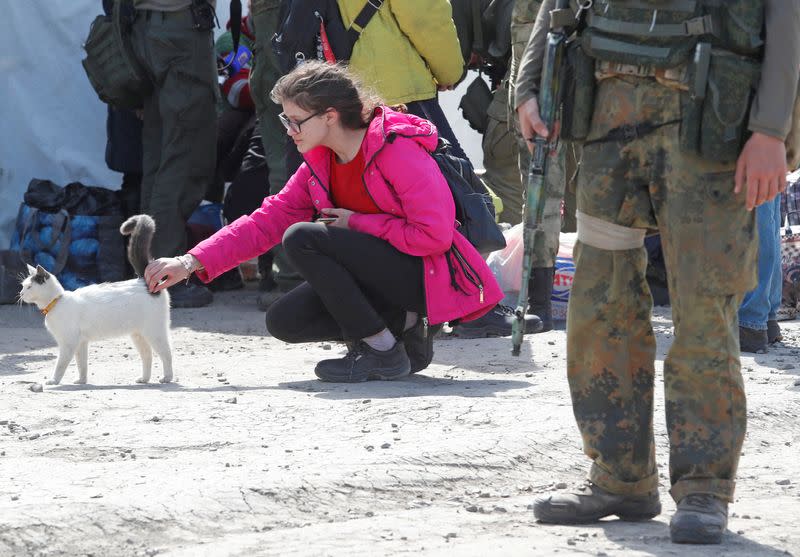 A young woman strokes a cat at a temporary accommodation centre in Bezimenne