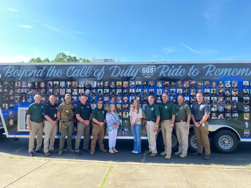 members of the MCSO and family of Deputy Terry Dyer stand beside Dyer's memorial.