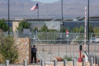 A security officer keeps watch over a tent encampment housing immigrant children just north of the Mexican border in Tornillo, Texas, U.S. June 20, 2018. REUTERS/Mike Blake