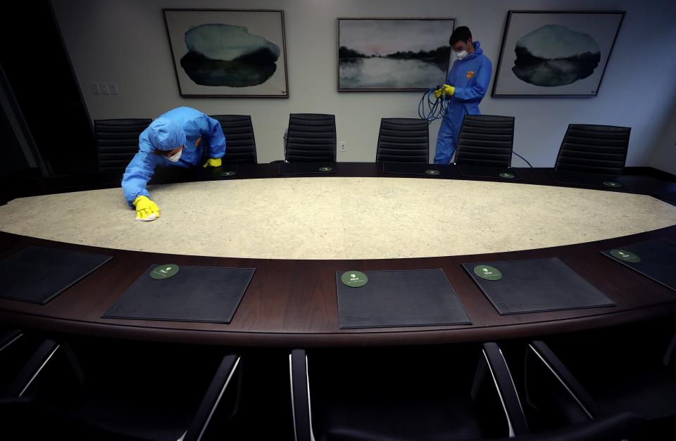 Maryland Cleaning and Abatement Services employees John Davis and Wyatt Young preform a preventative fogging and damp wipe treatment at an office building on March 21, 2020 in Hunt Valley, Maryland. The outbreak of the COVID-19 pandemic has sparked more proactive measures at businesses to combat the spread of the coronavirus.