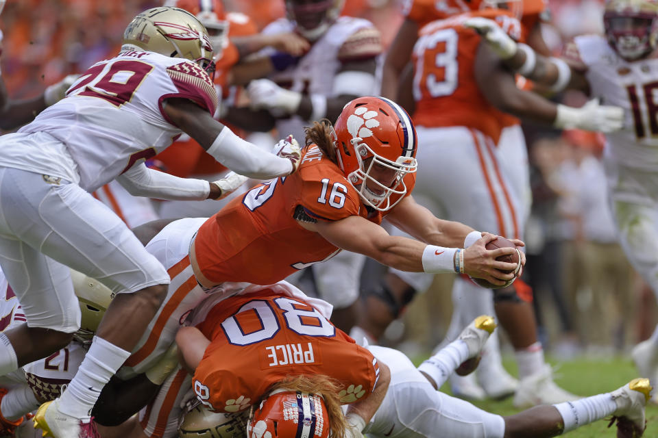 Clemson quarterback Trevor Lawrence (16) stretches out for a touchdown while defended by Florida State's Isaiah Bolden (29) during the first half of an NCAA college football game Saturday, Oct. 12, 2019, in Clemson, S.C. (AP Photo/Richard Shiro)