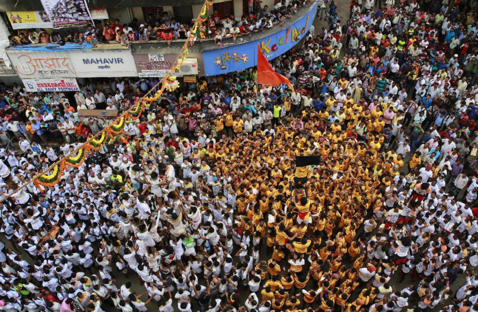 <p>Indian devotees show a black flag standing on the top of a human pyramid before breaking dahi handi, a pot filled with curd, during a protest against the Indian court order of imposing height restrictions on human pyramids formed during the festivities and banning youngsters below 18 years from participating, in Mumbai, India, Aug. 25, 2016. The holiday marks the birth of Hindu God Krishna. (Photo: Rafiq Maqbool/AP) </p>